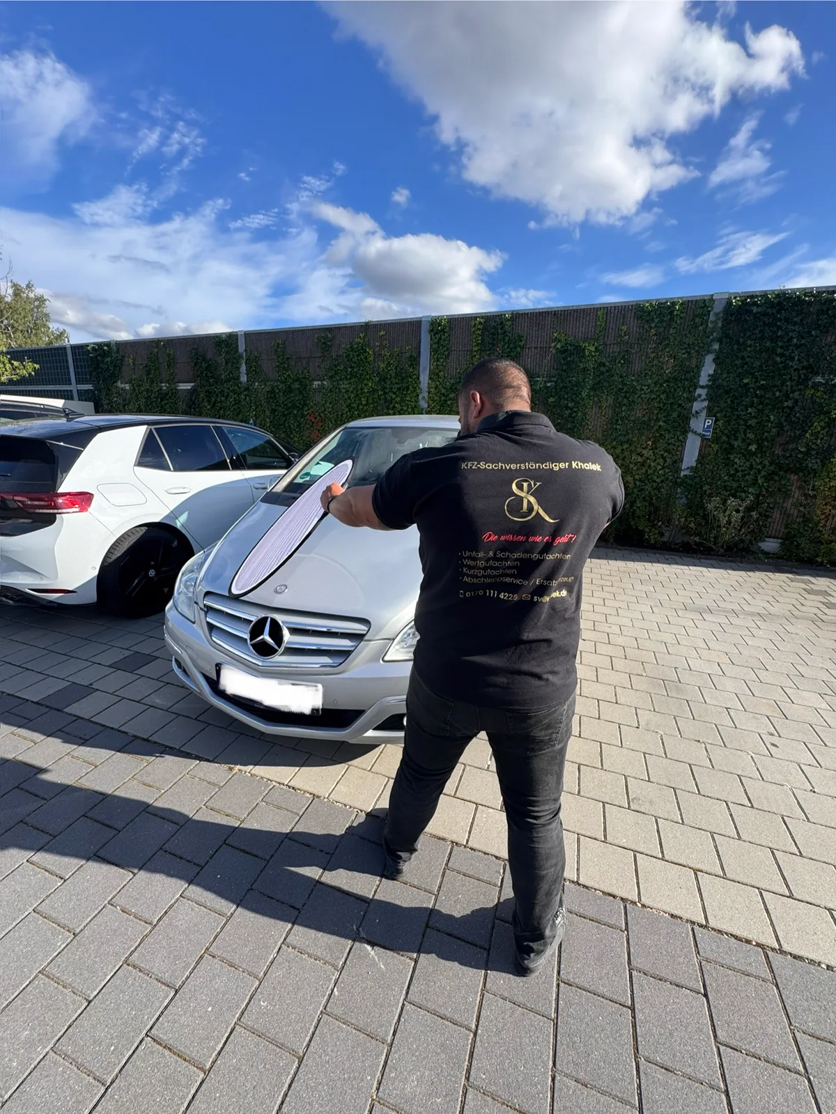 Herr Khalek prüft eine Motorhaube mit dem Reflexionssegel