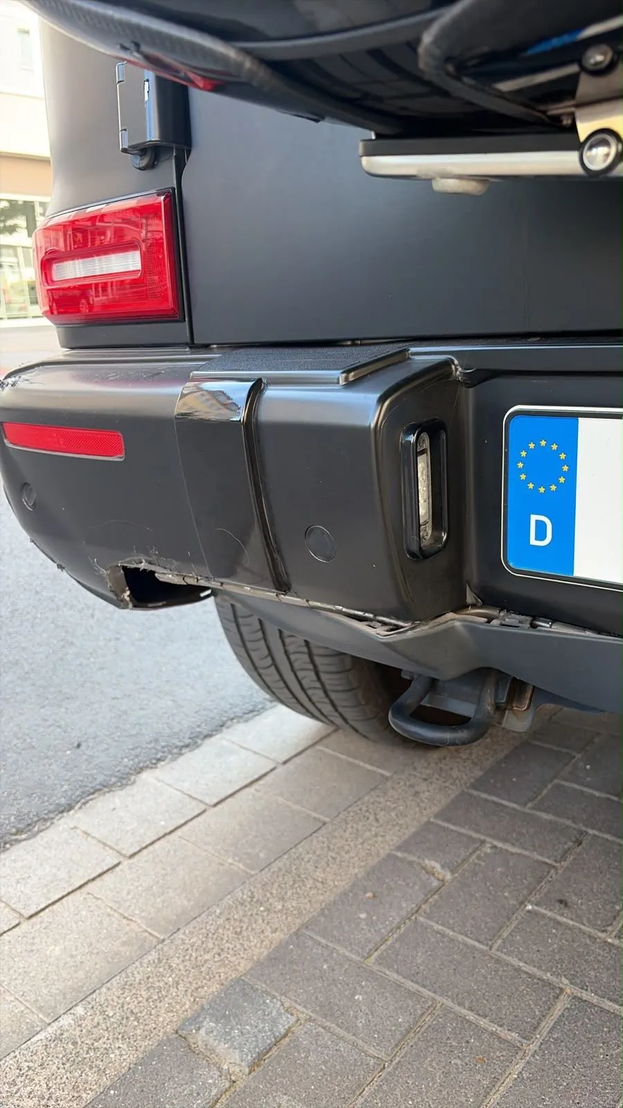 Aufgerissene hintere Stoßstange einer schwarzen Mercedes G-Klasse