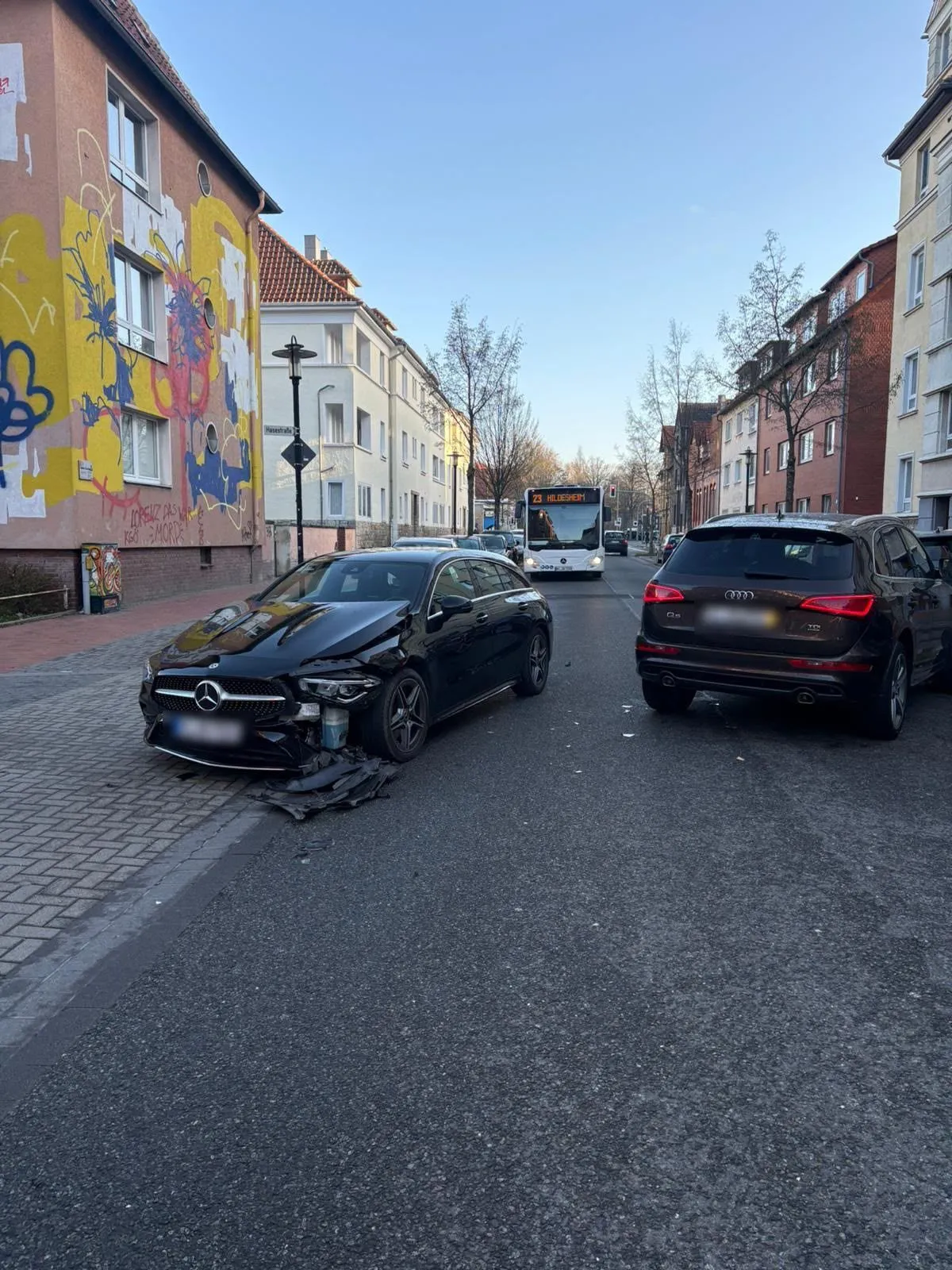 Unfallstelle mit beschädigtem Mercedes und Audi auf der Straße